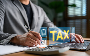Businessman calculating tax with laptop, calculator, and financial documents, online tax filing,...