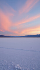 Tranquil landscape showcasing vast expanse of white snow under pastel sky at sunset, with soft pink and blue hues reflecting on horizon