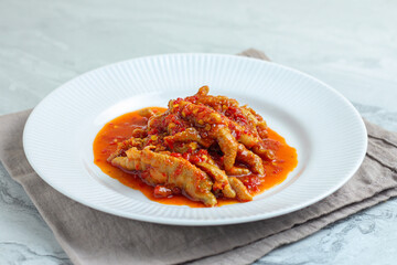 Dakbal. or Korean spicy chicken feet. Served on white plate.