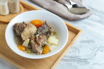 Beef vegetable soup served in a white bowl.