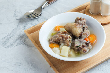 Beef vegetable soup served in a white bowl.