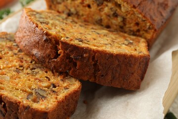Cut homemade carrot cake with nuts on table, closeup