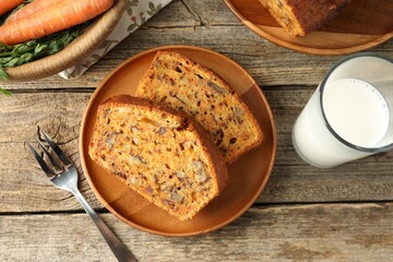 Homemade carrot cake with nuts, milk and vegetables on wooden table, flat lay