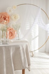Stylish room with burning candle, flowers and other wedding decor. Interior design