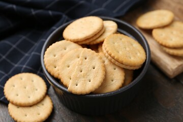 Tasty salty crackers on wooden table, closeup
