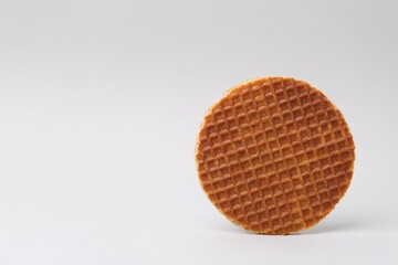 One tasty round waffle on white background. Space for text