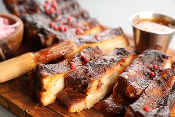 Delicious pork ribs and brush on grey table, closeup