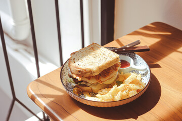Whole wheat sandwich toast with crispy chicken, sunny side egg, and sauce. Breakfast concept in the morning