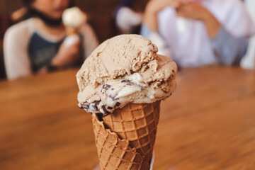 Close up view of gelato ice cream with people eating together as blurred background
