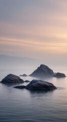 Fototapeta premium Serene landscape features smooth rocks emerging from calm water, surrounded by soft mist and gentle hues of dawn. tranquil scene evokes sense of peace and solitude