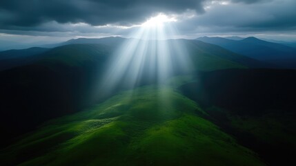Sunbeams piercing through clouds over lush mountain range