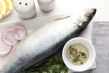 Salted herring and spices on white table, flat lay