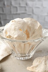 Delicious homemade meringue cookies in bowl on gray table, closeup