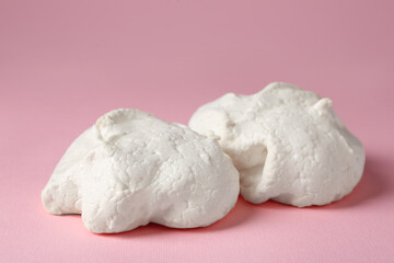Delicious homemade meringue cookies on pink background, closeup