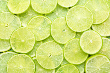 Slices of fresh limes as background, top view