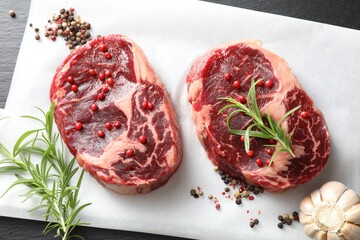 Pieces of raw beef meat and spices on table, flat lay