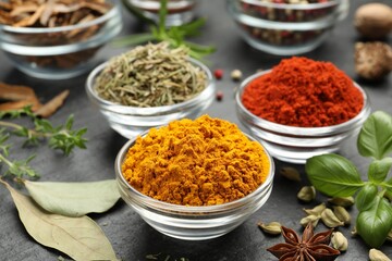 Different aromatic spices on grey table, closeup