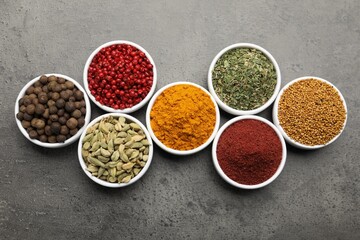 Different aromatic spices on grey table, flat lay