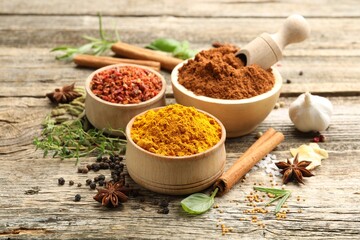 Different aromatic spices on wooden table, closeup