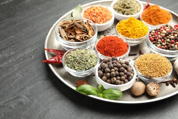 Different aromatic spices on black table, closeup. Space for text