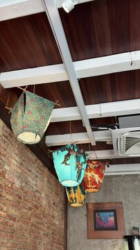 old and traditional lampions made from kain batik, or batik cloth hanging on the ceiling of an vintage house or building. industrial concept, interior design. South East Asian style of art and craft