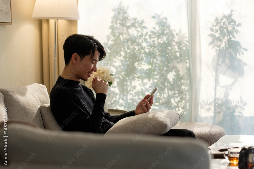 Poster casual man using a smartphone while lounging on the couch.