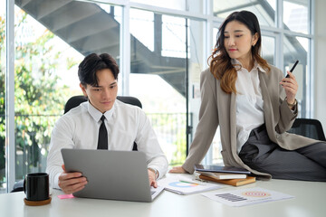 Confident executives planning business strategies with digital devices and printed reports in a sleek office environment.