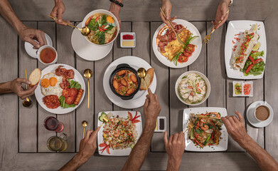 Delicious European and Asian cuisine on the big table. Group of people eating at  serving table. table with food, top view
