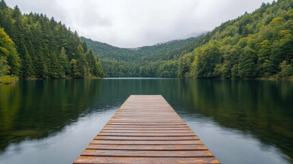 Serene lake view with wooden dock surrounded by lush green forests and mountains