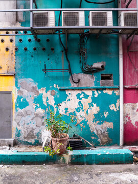 Weathered colorful wall with air conditioners and urban plant Kuala Lumpur