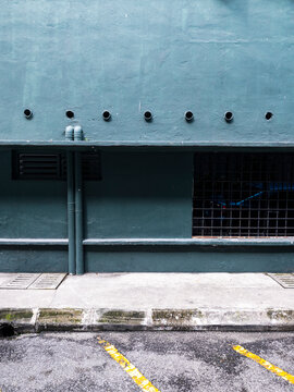 Green wall with pipes and parking lines