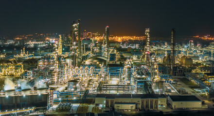 Fototapeta premium Large petrochemical plant and oil refinery complex glowing at night.