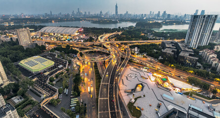 Fototapeta premium Panoramic of modern cityscape featuring complex road interchange and illuminated skyline at dusk in Nanjing, China.