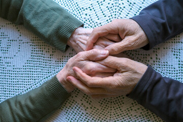 Elderly Hands Showing Care and Support on a Light Background
