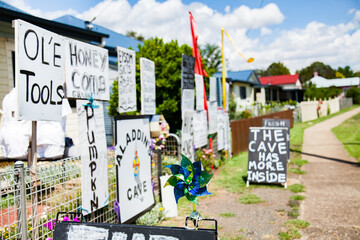 Lots of hand written signs advertising things for sale outside home on street