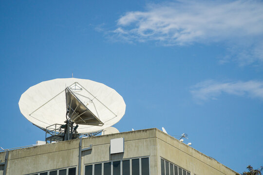 Large telecommunications dishes on rooftop of a building