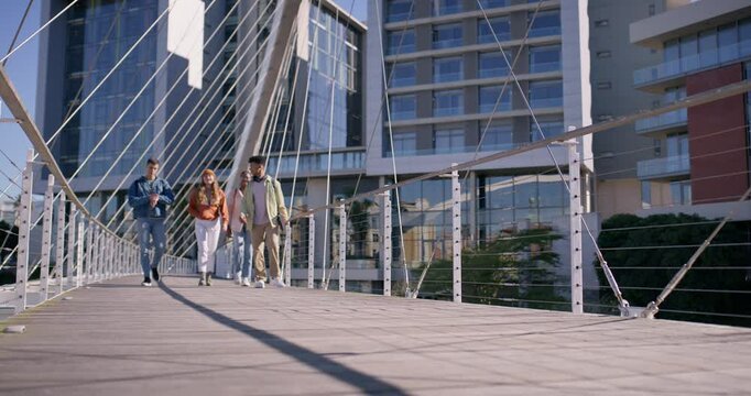 Students, group and walking in city with diversity, talk and ready for learning, education or school. People, bridge and gen z friends with backpack, chat or check watch for class schedule at campus
