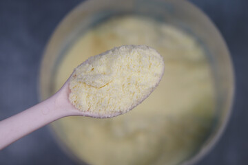 spoon pick milk powder from a container 