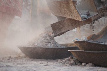 Dusty gravel extraction process in a quarry during daylight hours