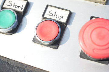 Control panel with start and stop buttons in industrial setting