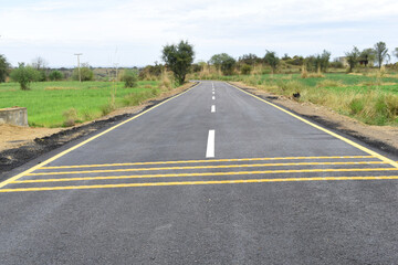 Newly constructed asphalt road with clipping path, asphalt highway road with sky clouds natural landscape, asphalt road passing through agricultural fields under blue sky in Chakwal, Punjab, Pakistan