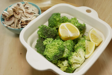 Fresh broccoli and lemon preparation on kitchen counter