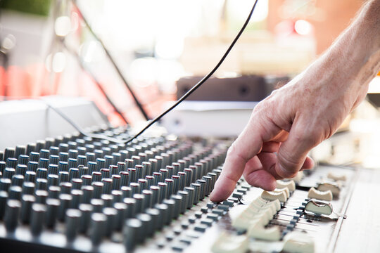 Hand adjusting knobs on a sound system audio mixer