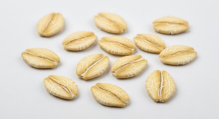 Obraz premium Scattered view of rolled oats on a white surface showing texture and shape in a close up shot