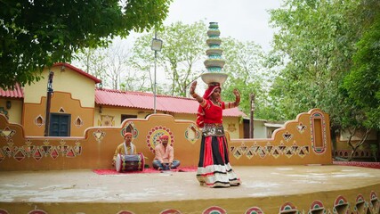 Rural artist dances balancing clay pots on head outdoor