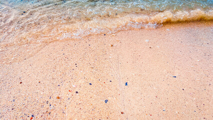 A beautiful sandy beach with soft blue ocean waves gently washing the shore.sand and sea.