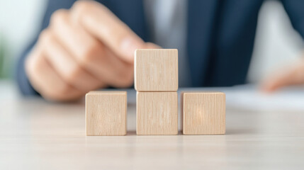 Wooden cubes stacked by hand. Hands floating above a pile of blocks. This concept represents sustainability.
