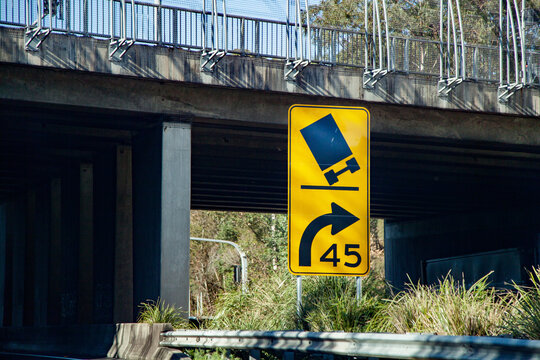 Sharp bend tilting truck sign with recommended speed