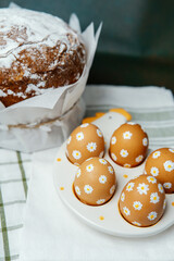 Easter cake and daisy Easter eggs in a chicken plate. Festive background.