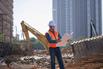Engineer worker operations construction plans large black drainage pipe installing underground...